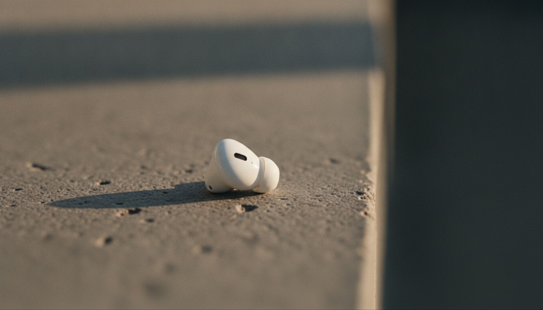 Infrared sensörlü AirPods modeli, mat taş yüzey üzerinde yakın çekim