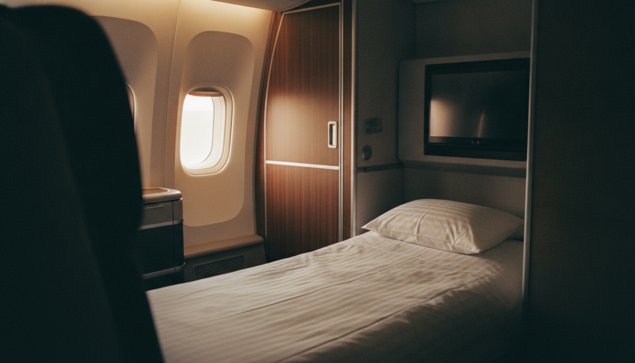 Cathay Pacific 777-300ER Aria Suite business class kabininin içi, kapalı mahremiyet kapısı ve flatbed koltuğuyla