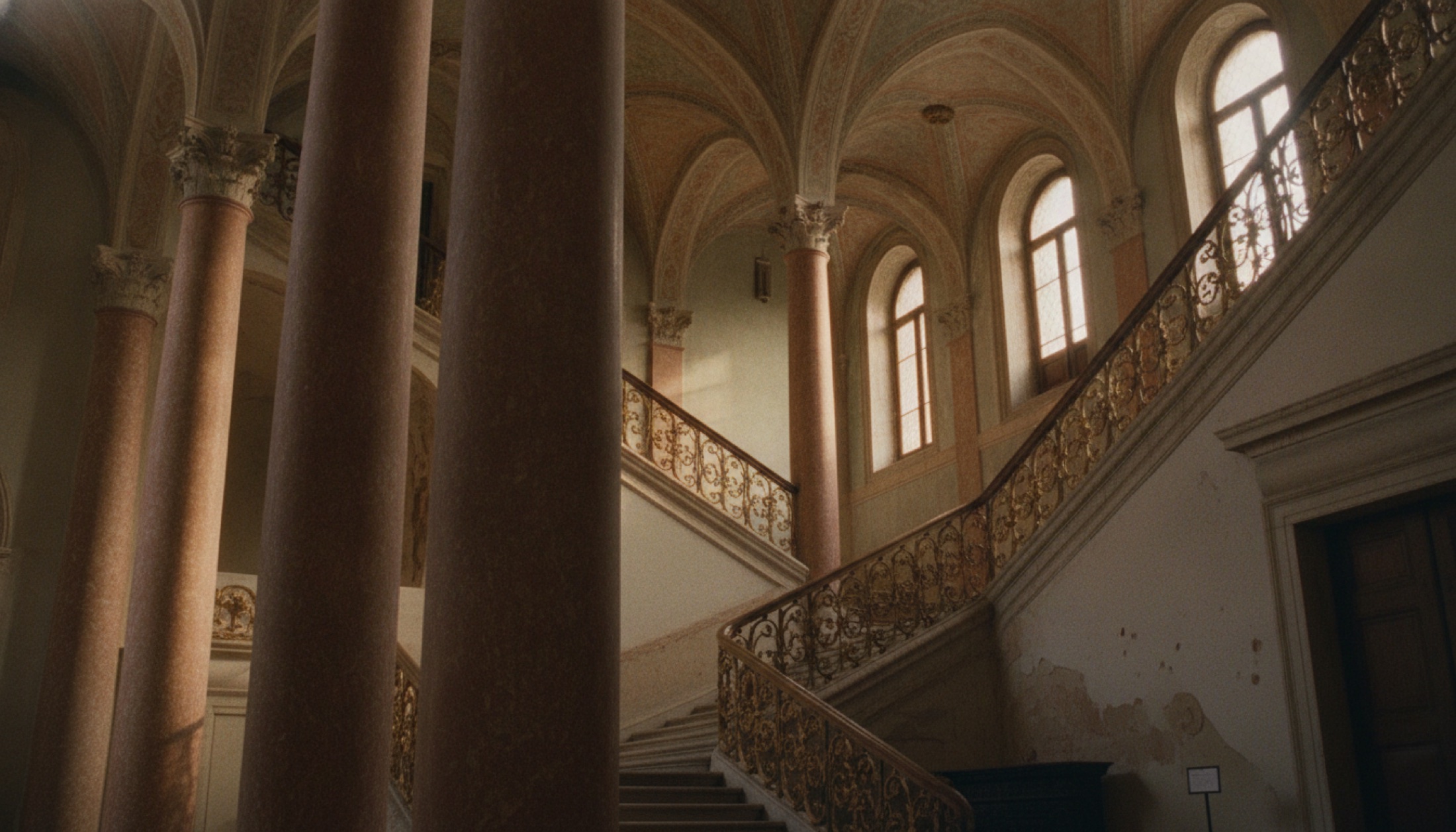 Palazzo Dandolo'nun dört katlı pembe mermer atriumu, altın yaldız merdiveni ve yukarıya uzanan sütunlarıyla