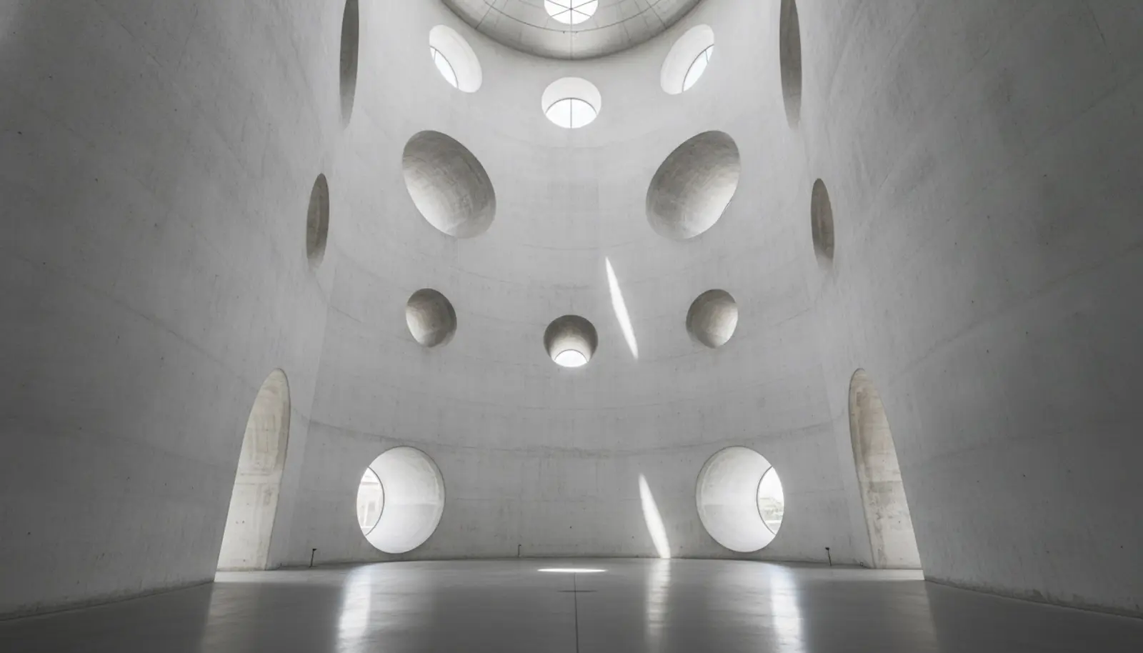 Çağdaş sanat müzesinin iç mekanı — silo mimarisine ait yuvarlak formlar, yüksek beyaz duvarlar ve dairesel pencerelerden süzülen doğal ışık