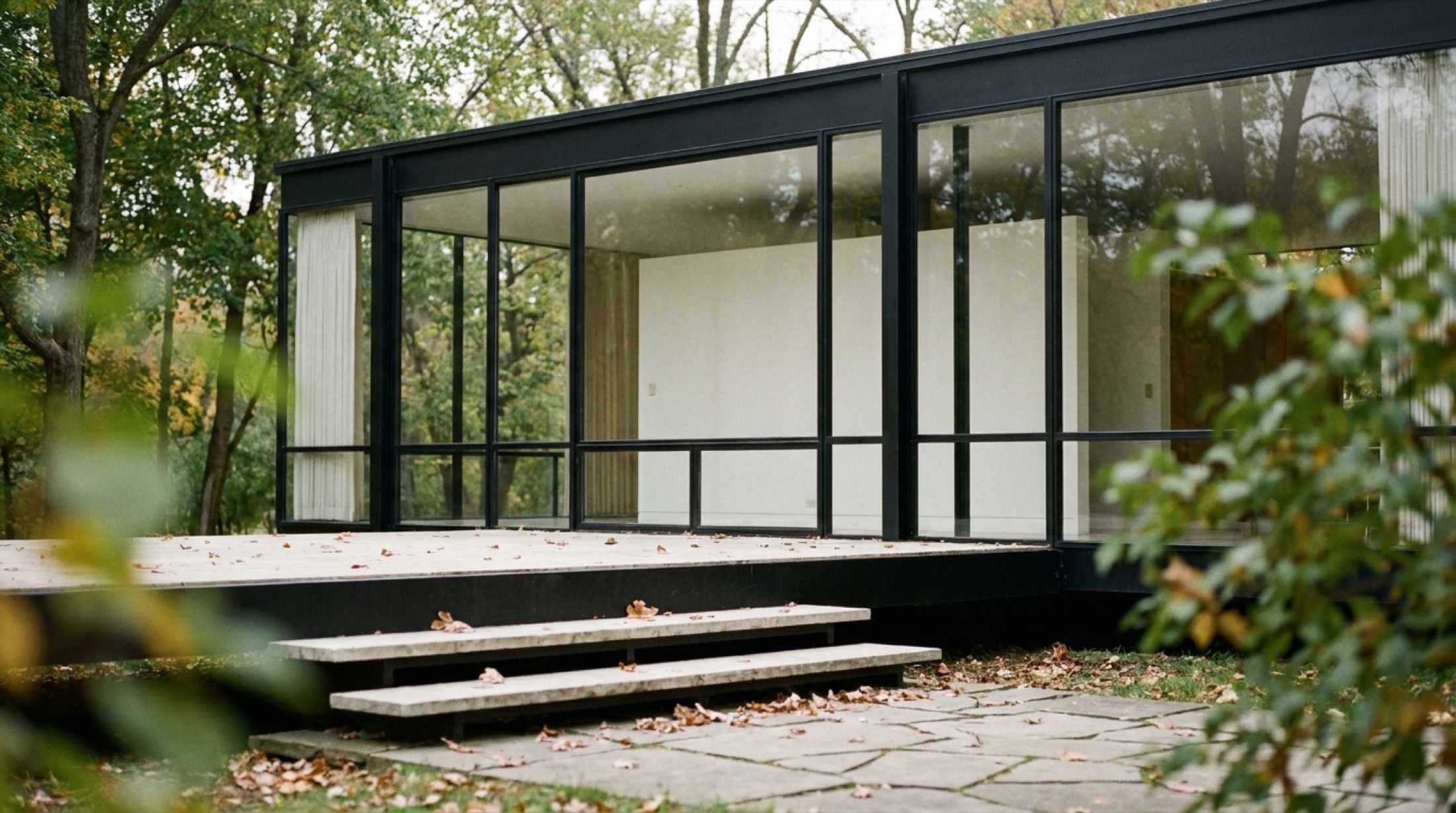 Mies van der Rohe'nin Illinois'taki Farnsworth House cam ve çelik yapısı, yeşil orman arka planında
