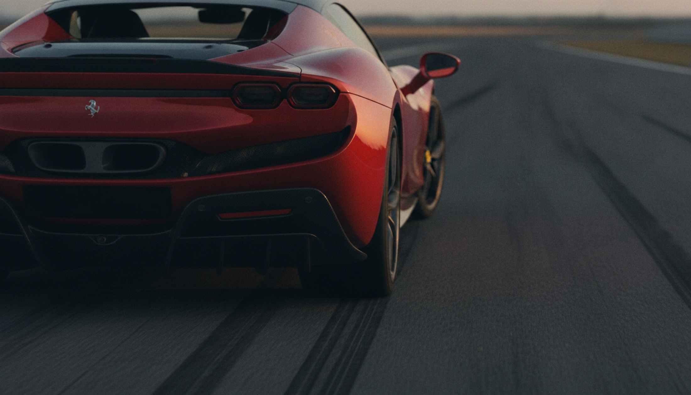 Ferrari 296 Speciale arka üç çeyrek açıdan, karbon fiber difüzör ve aerodinamik yüzeyler, alacakaranlık ışığında pist ortamı