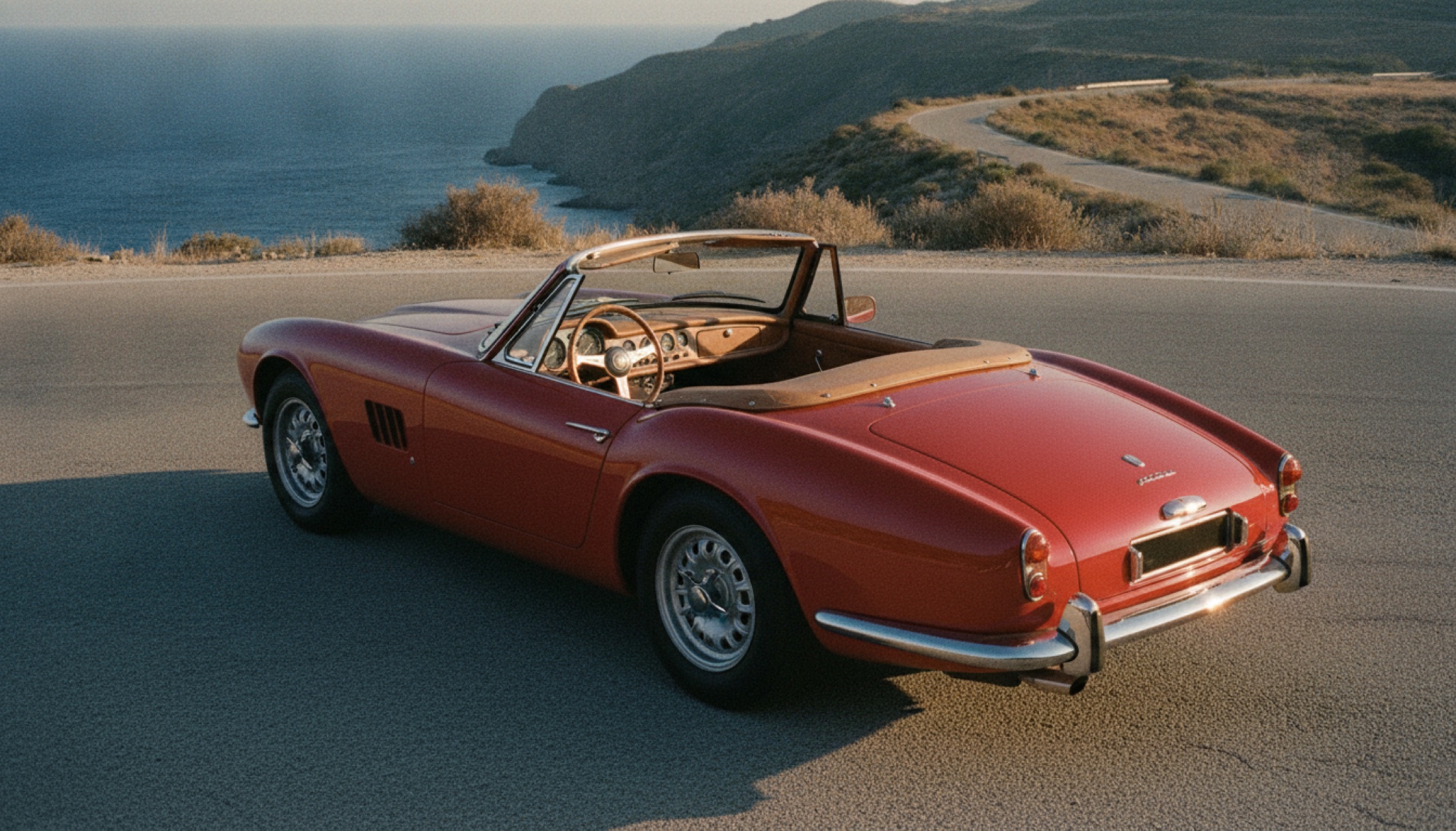 Kırmızı üstü açık Ferrari Amalfi Spider kıyı yolunda gün batımı ışığında