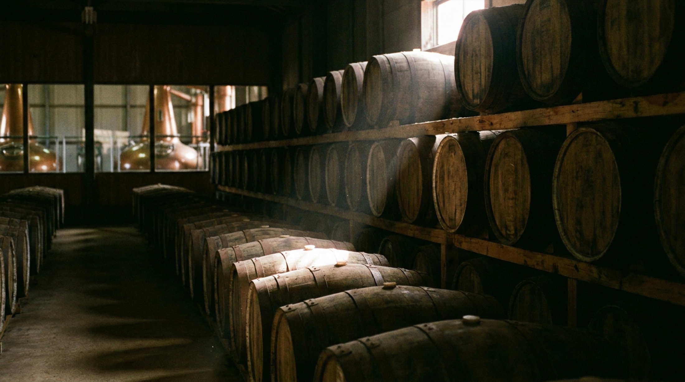 Japon damıtımevinde meşe fıçılarda olgunlaşan single malt viski; arka planda bakır imbiklerin loş ışıkta yansıması