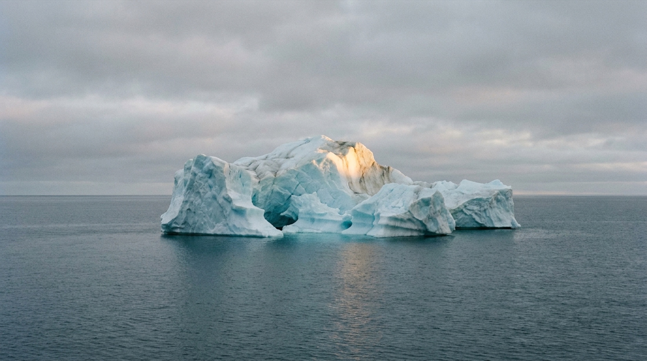 Arktik denizinde yüzen dev mavi buzdağı, altın saatte polar ışığıyla