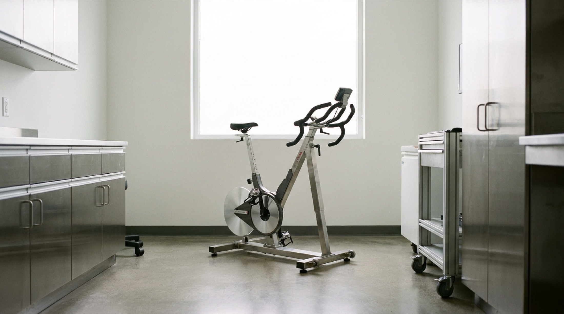 Minimalist klinik muayene odasında VO2max test bisikleti, steril beyaz ışık
