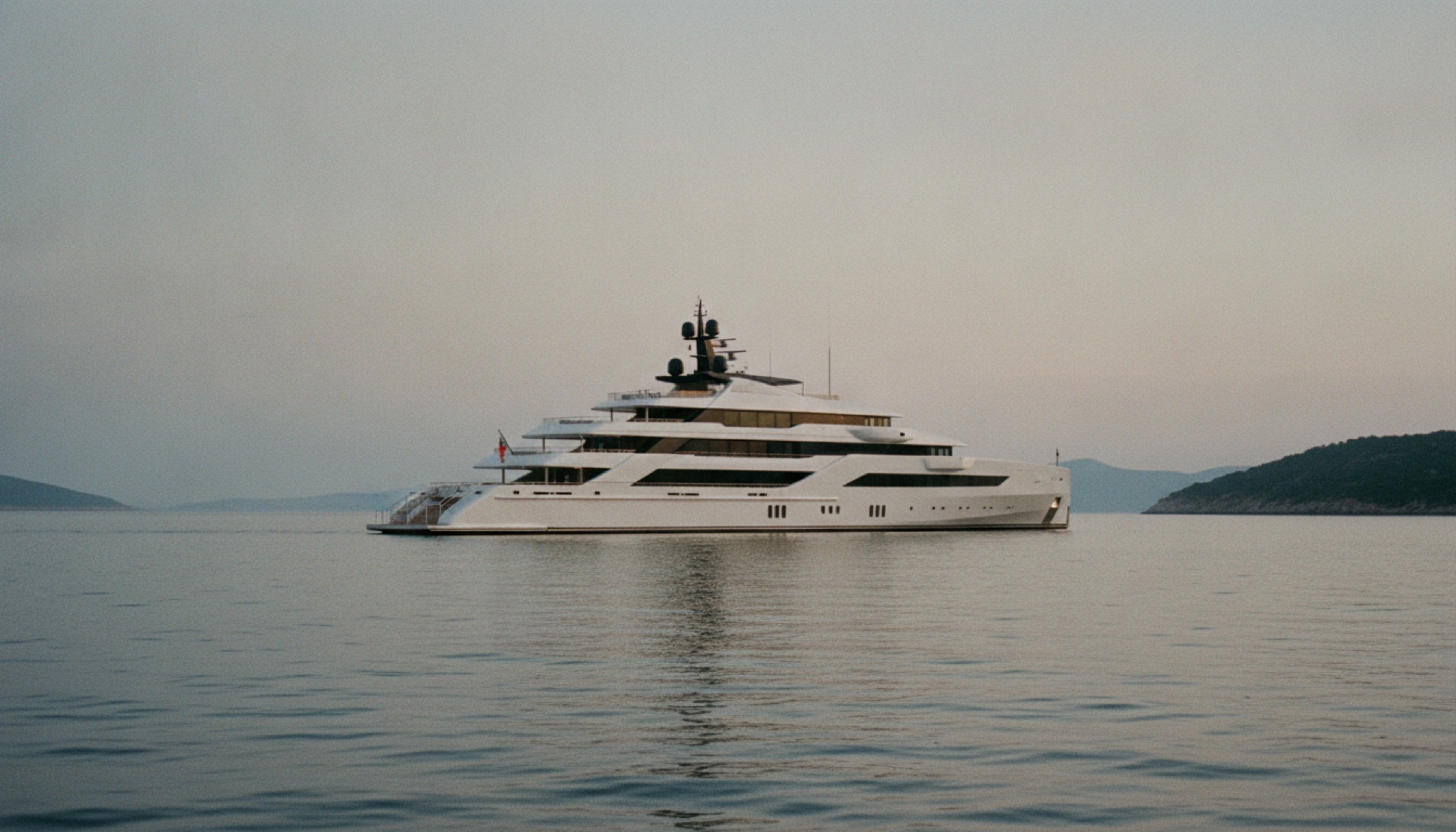 Akdeniz koyunda demirli, geometrik süperstrüktürlü büyük modern superyacht, alacakaranlıkta