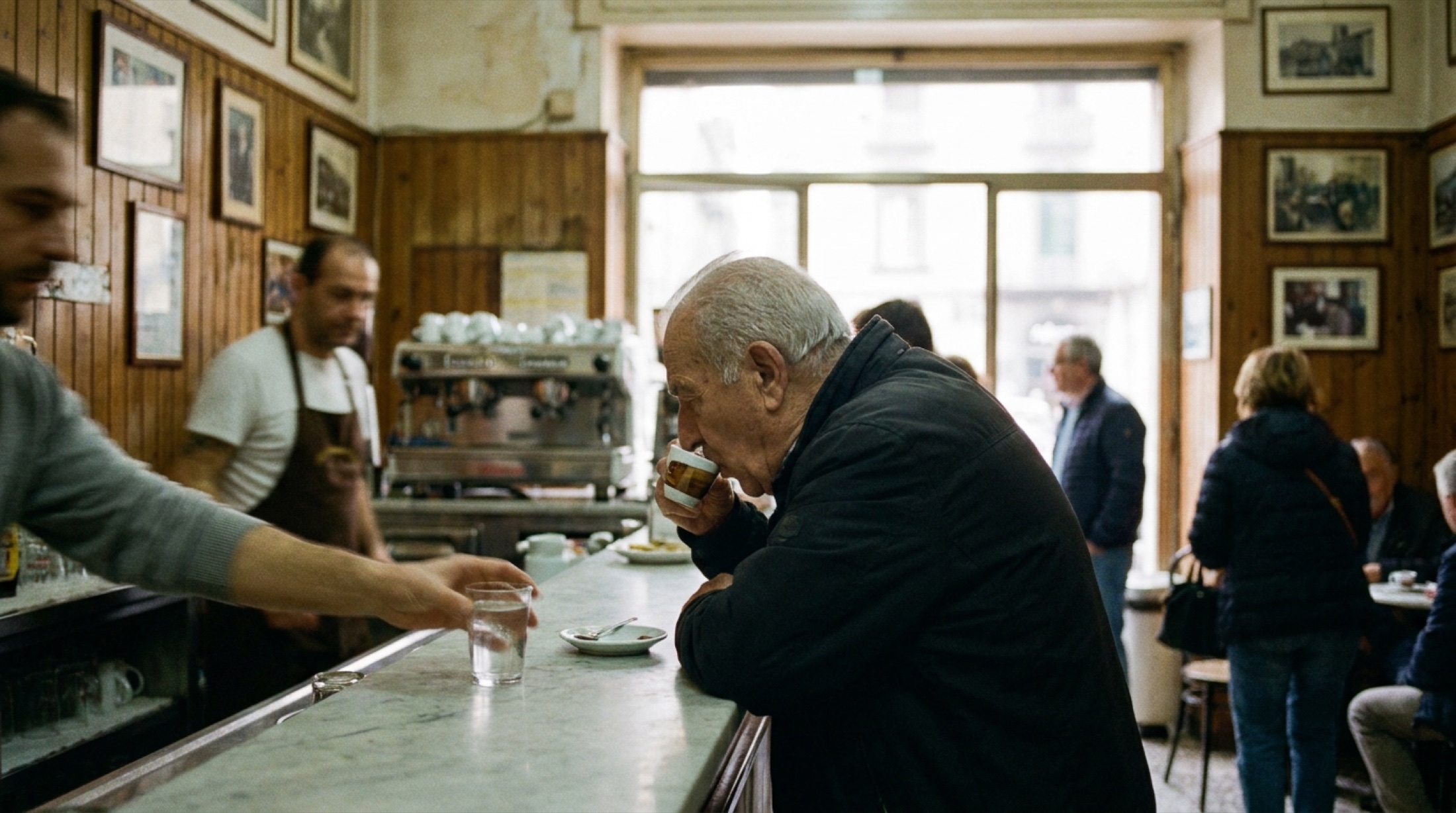 Napoli'de küçük bir barın içi, mermer tezgâh ve arka duvarda espresso makinesi