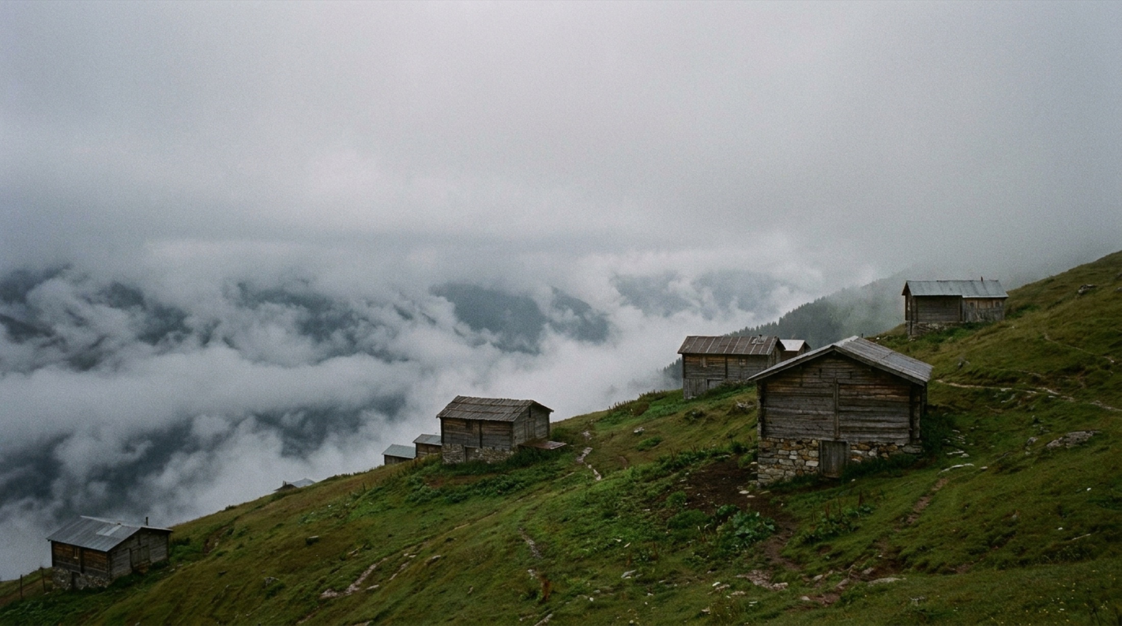 Rize Pokut Yaylası'ndaki ahşap evler ve aşağıda uzanan bulut denizi, insan yok
