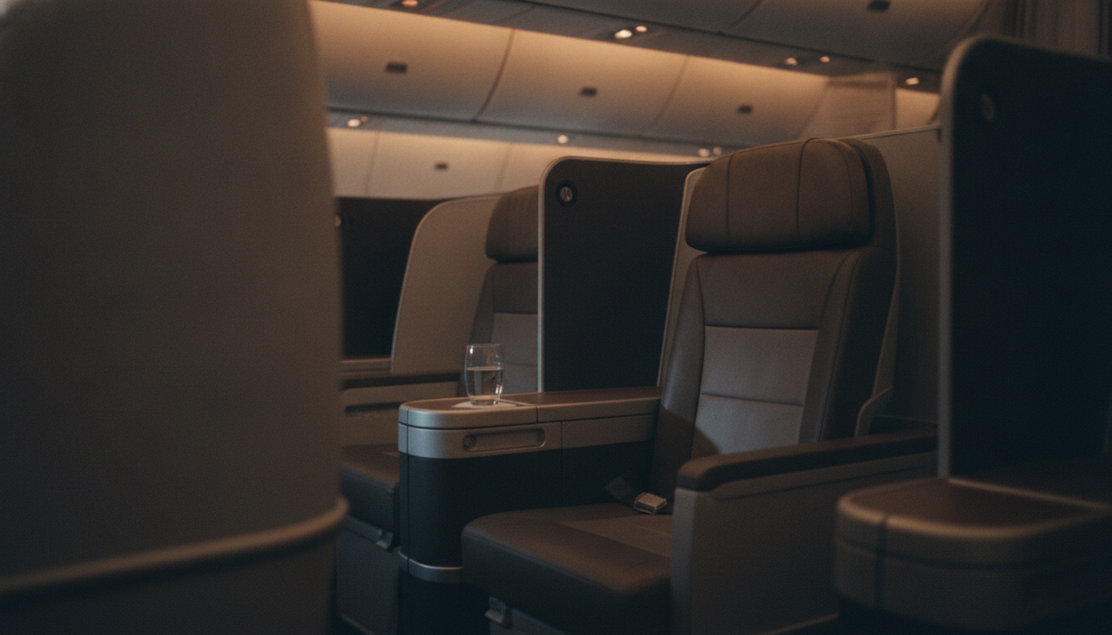 Geniş govdeli uçak business class kabininde dolaylı ışıklandırmalı koltuk sıraları